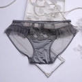 Détail de culotte en satin gris avec broderie de feuilles et volants en dentelle fine - Gris