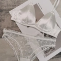 Elegantes weißes Satin-Dessous-Set mit Herzmuster-Spitze auf einem Modemagazin liegend - XL / Weiß