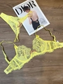 Detail of vibrant yellow sheer lace lingerie set with bow accents on wooden background - Yellow