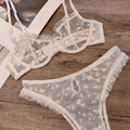 Flat lay of white lace lingerie set with heart patterns on a wooden texture background - White