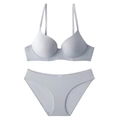 Macro shot of seamless light grey lingerie set with thin straps and laser-cut edges - Gray