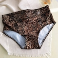 Detailed flat lay of high-waisted leopard print bikini bottoms on white fringe mat - Leopard Print
