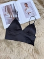 Dettaglio di un bralette in raso nero con spalline sottili su fondo morbido peluche - S / Nero