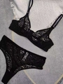 Vista piatta di un set di lingerie in pizzo nero con motivo leopardato e spalline sottili - S / Nero