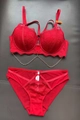 Detail of red lace bra with delicate floral patterns and gold decorative chains - Red