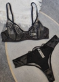 Flachbild von schwarzem Spitzen-BH und Thong-Set mit Punktbestickung auf grauem Grund - S / Schwarz