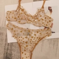 Flat lay of sheer lace lingerie set featuring yellow heart prints and ruffled trim details - Brown