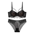 Detail of black lace bra with eyelash trim and matching mesh panties set on white background - Black