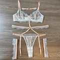 Dettaglio in piano di set lingerie in mesh azzurro con pizzo a quadri su legno - S / Celeste
