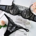 Détail d'un ensemble de lingerie en dentelle noire avec tissu résille sur fond à plat - S / Noir