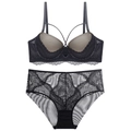Détail d'un ensemble de lingerie en dentelle noire avec sangles croisées et résille - Noir