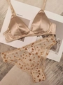 Détail d'un soutien-gorge en satin champagne et d'une culotte en mesh à cœurs sur fond déco - S / Khaki