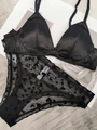 Détail d'un soutien-gorge en satin noir et d'une culotte en maille à motifs de cœurs - S / Noir