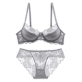 Elegante conjunto de lencería de encaje gris con flores y lazos sobre un fondo blanco puro - Gris Set / 70A