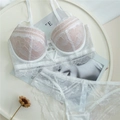 Elegantes weißes Blumen-Spitzen-Lingerie-Set mit Bügel-BH und passendem Slip flachgelegt - 70B / Weiß