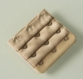 Detail view of 3-hook bra extender in beige fabric with durable metal hooks - One Size / Nude