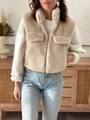 Dettaglio di un gilet beige in pelliccia sintetica con collo alto e zip in metallo - S / caffè