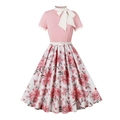 Detail of vintage pink dress featuring a large white bow tie and floral print skirt - S / Pink