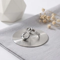 Modern irregular geometric stainless steel ring with a polished mirror finish on a pedestal - One Size / Steel