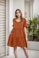 Close-up of rust red tiered dress featuring a V-neckline and delicate ruffle sleeves - S / Caramel color
