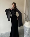 Detail eines eleganten schwarzen Abendkleids mit drapiertem Oberteil und weiten Netzhülsen - S / Schwarz