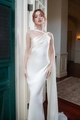 Detail van elegante witte satijnen jurk met een chique one-shoulder cape en zeemeermin snit - S / Melkwit