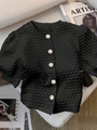 Detailed close-up of textured seersucker fabric and pearl buttons on black shirt - S / Black