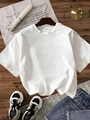 T-shirt blanc ample avec short en jean délavé et baskets sur un fond en bois rustique - Blanc
