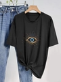 Minimalistisch zwart T-shirt met gouden evil eye print op een houten kleerhanger - S / Zwart