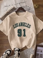 T-shirt beige Los Angeles 91 su stampella in legno con accessori casual in stile street fashion - S / Cachi