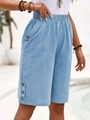 Detail of light blue linen shorts featuring decorative wooden buttons on the leg hem - S / Light Blue