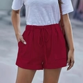 Dettaglio degli shorts rossi a vita alta con coulisse elastica e ampie tasche a contrasto - S / Rosso Scuro