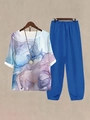 Detail of floral print top with tulip hem blue pants and matching necklace set - S / Top And Bottom / Blue and Purple Abstract Print