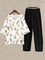 Close-up of women's two-piece set with floral print top and black wide-leg trousers - S / Top And Bottom / Black and White Feather Print