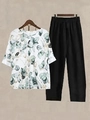 Close-up of floral print two-piece lounge set with elastic waistband and soft fabric - S / Top And Bottom / White/Black (Green Leaf Print)