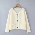 Dettaglio del cardigan in maglia traforata bianco crema con bottoni marroni e tasche - Taglia S / Bianco avorio