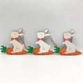 Three wooden Easter pendants featuring a cartoon white rabbit riding an orange carrot - Rabbit Riding Carrot Style (HF10805)