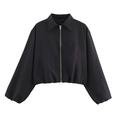 Detail einer schwarzen Kurzjacke mit goldenem Reißverschluss und elastischen Bündchen - Schwarz