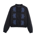 Détail d'une veste matelassée noire avec broderies florales bleues et pressions - Noir