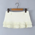Detail of cream pleated mini skirt showing layered fabric textures and waistband on a hanger - S / Off White