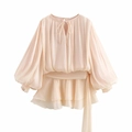 Close-up of lantern sleeves and ruffled hem on an apricot puff sleeve mini dress - Apricot
