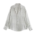 Close-up detail of a minimalist white striped shirt showing the collar and button placket - Striped