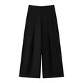 Detail of high-waist black wide-leg trousers featuring sharp pleats and draped fabric - Black