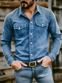 Close-up of men's long-sleeve denim shirt featuring double chest pockets and pearl buttons - Blue