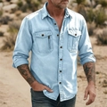 Detail of light blue denim shirt featuring utility pockets and metallic zipper accent - Light Blue