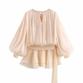 Macro shot of apricot pleated chiffon dress detailing tiered ruffle hem and bishop sleeves - S / Off White