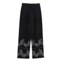 Detalle del bordado floral en el dobladillo del pantalón negro de talle alto y pierna ancha - XS / Bottoms / Negro