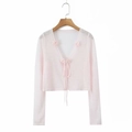 Close-up of pink sheer bolero cardigan with floral crochet lace and front ribbon ties - One Size / Pink