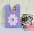 Detailed view of purple knitted tote bag featuring floral patterns and spring return text - Purple Sunflower