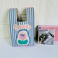 Detailed macro view of the knitted tote bag with pink tulip design and flower embroidery - Striped Blue Tulip
